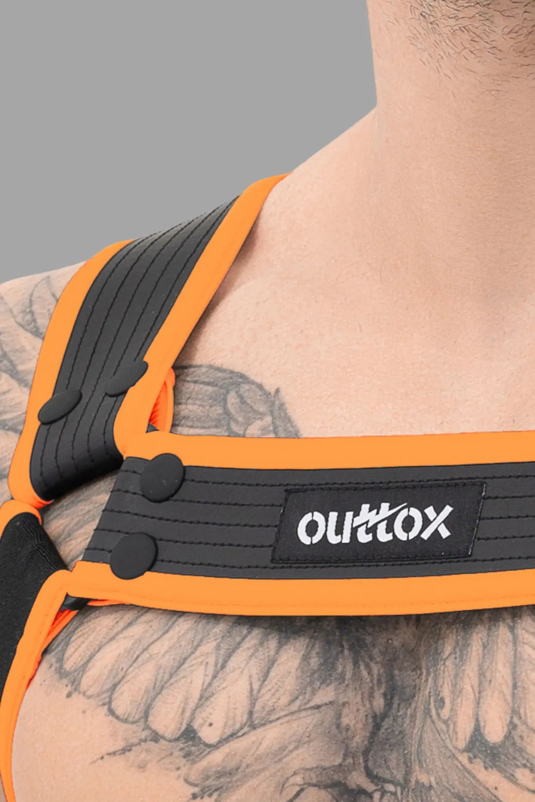 Outtox. Arnés corporal con broches. Negro y naranja.